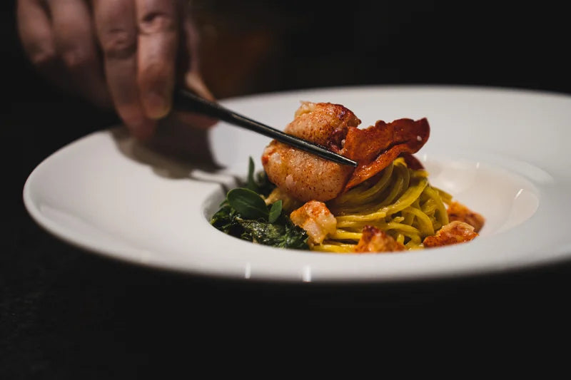 Chef finishing a plated dish at Aubergine