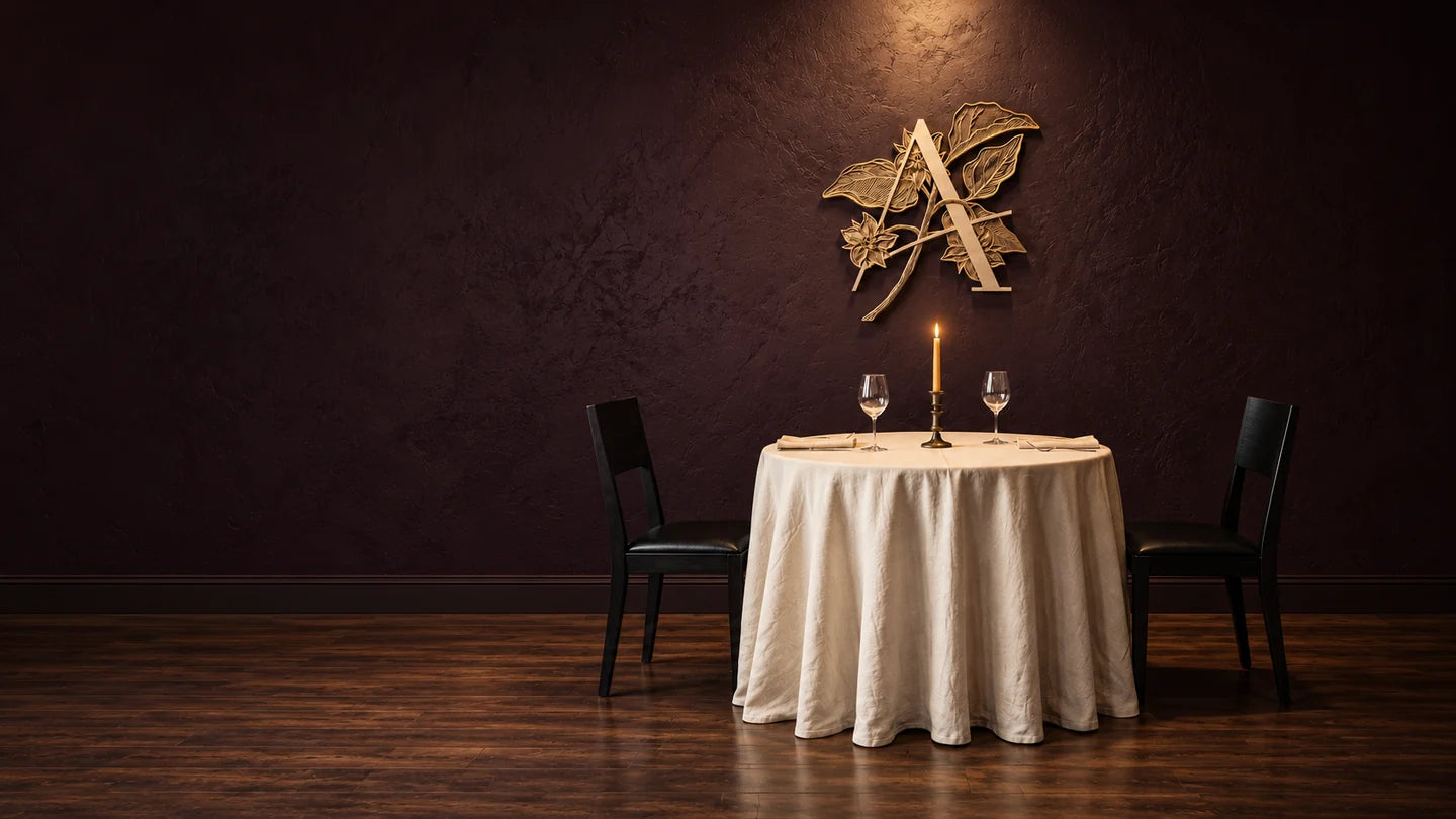 Candlelit dining-room composition with the gold Aubergine crest, an ivory linen table for two, and dark wooden chairs