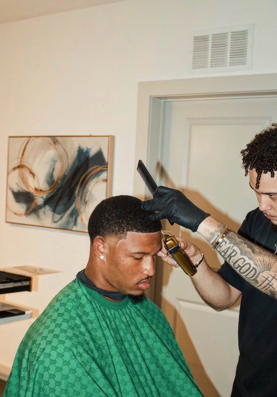 Anthony Sessa shaping a client’s hairline with clippers